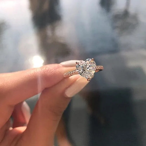 White gold alloy heart-shaped ring with AAA zircon stone on a light background