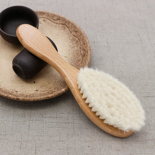 Beech wood baby shampoo brush with goat wool bristles in primary colour finish.