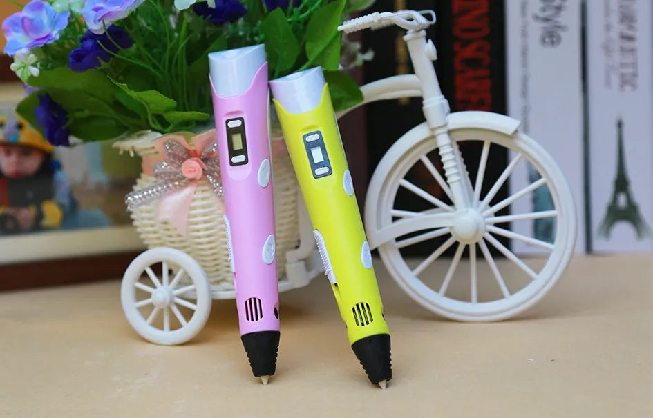 Yellow 3D printing pen with PLA filament spool on a white surface, showing nozzle and controls