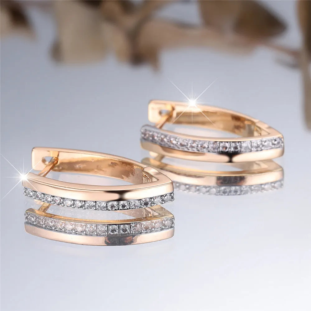 Women's geometric V-shape ear clips in champagne gold with white diamond detail on copper construction