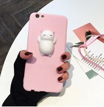 A soft pink silicone iPhone case with a raised 3D cartoon cat design on the back.
