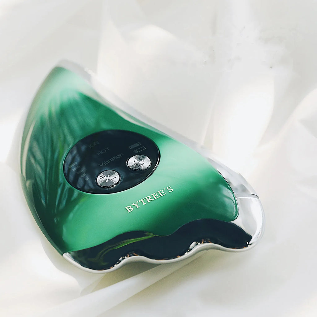 Green facial beauty instrument with vibration, hot and cold modes, and EMS micro current on a table