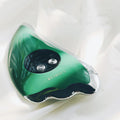 Green facial beauty instrument with vibration, hot and cold modes, and EMS micro current on a table
