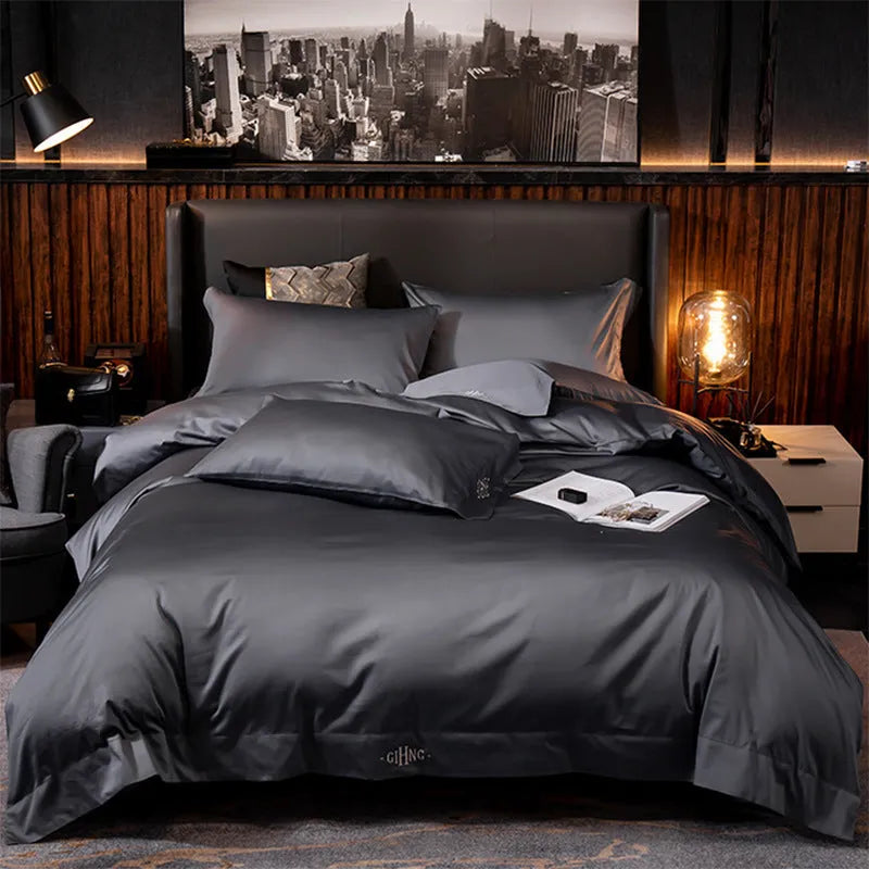 Four-piece cotton satin quilted bedding set with duvet cover, sheet, and pillowcases in a bedroom setting