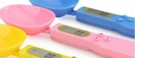 White digital spoon scale with LCD display measuring 500g capacity on a kitchen surface
