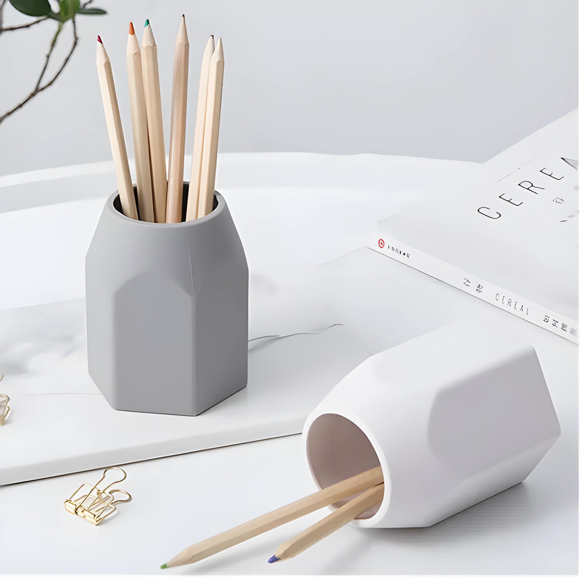Round silicone pen holder in grey, 80x95mm, on a desk holding pens and pencils