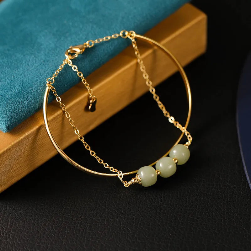 Hetian jade bracelet with gold inlay in single, double, and three bead versions on a wrist.