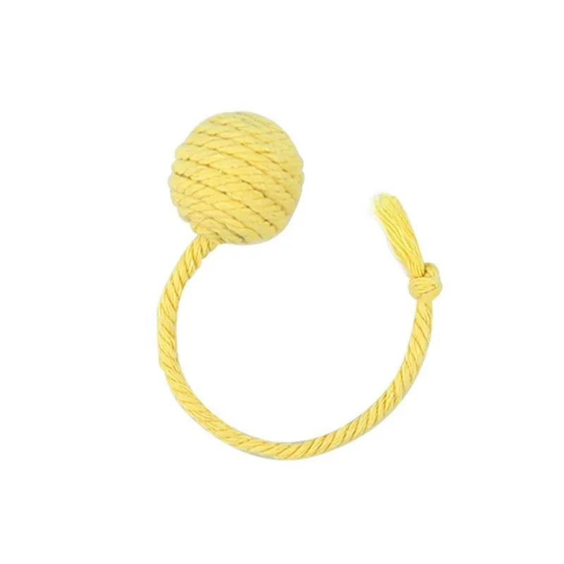 Green cat toy ball with attached rope and internal bell next to a pink one.