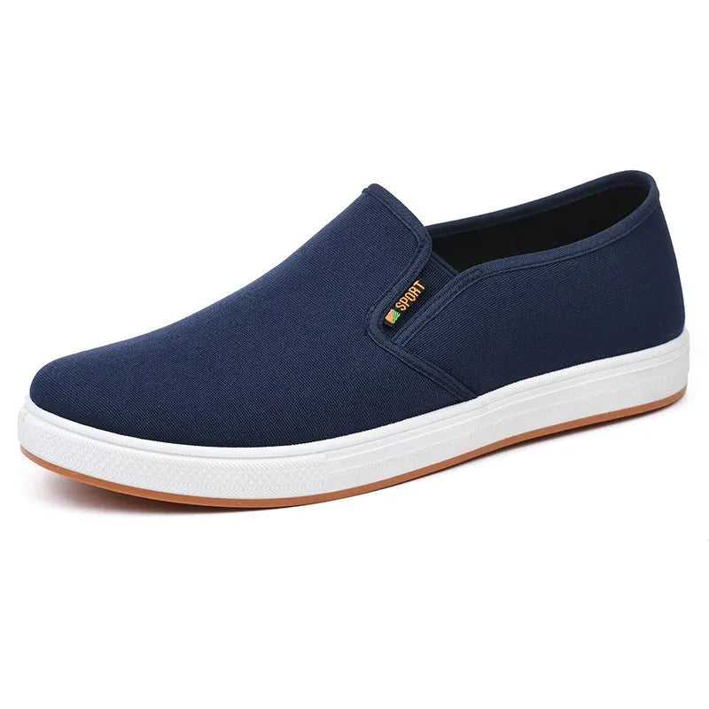 Men's black slip-on canvas trainers with round toe and low-top design on a white background