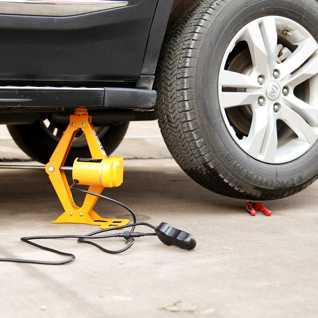 Vehicle-mounted electric hydraulic jack kit with a 2-tonne capacity on a grey background.