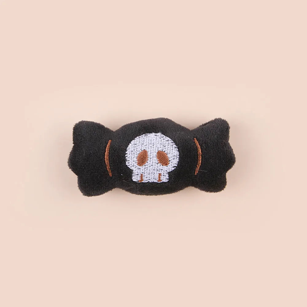 Plush cat teaser toy with candy, eyes and skull attachments on handheld wand