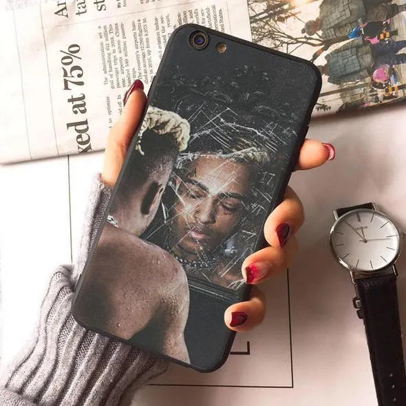 Matte transparent iPhone case with XXXTentacion pattern, showing half-wrapped design on an iPhone.