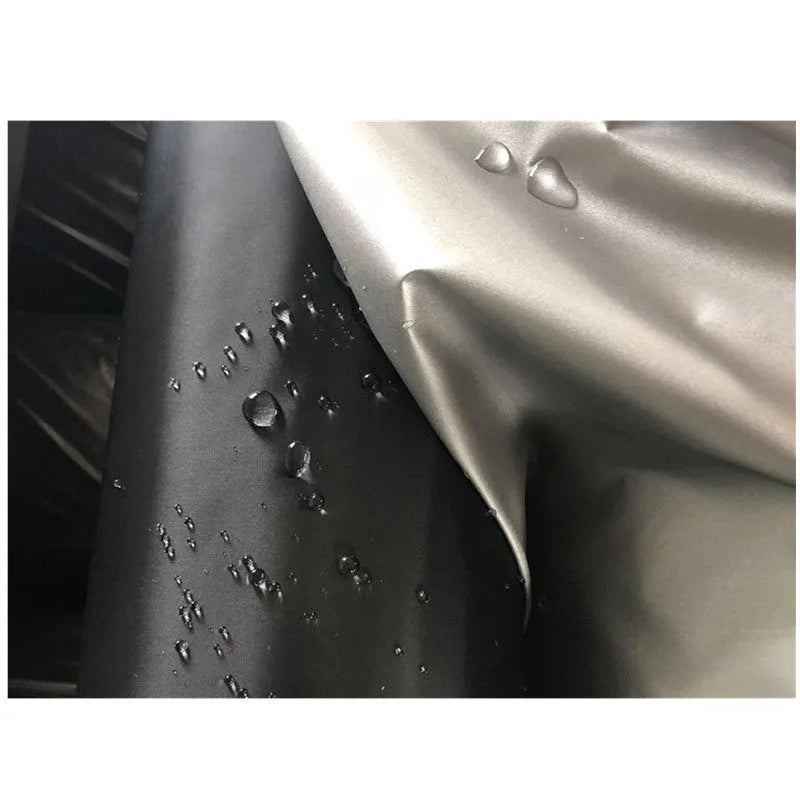Silver-coated black taffeta universal car cover fitted over a sedan in outdoor parking