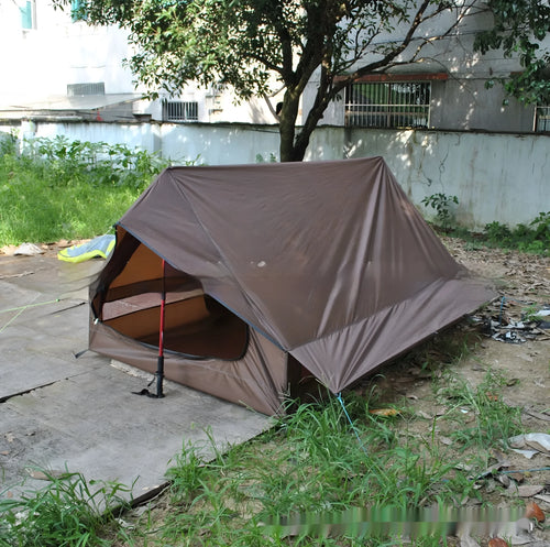 Brown A-line cabin tent pitched using hiking poles with aluminium ground nails and fluorescent wind ropes