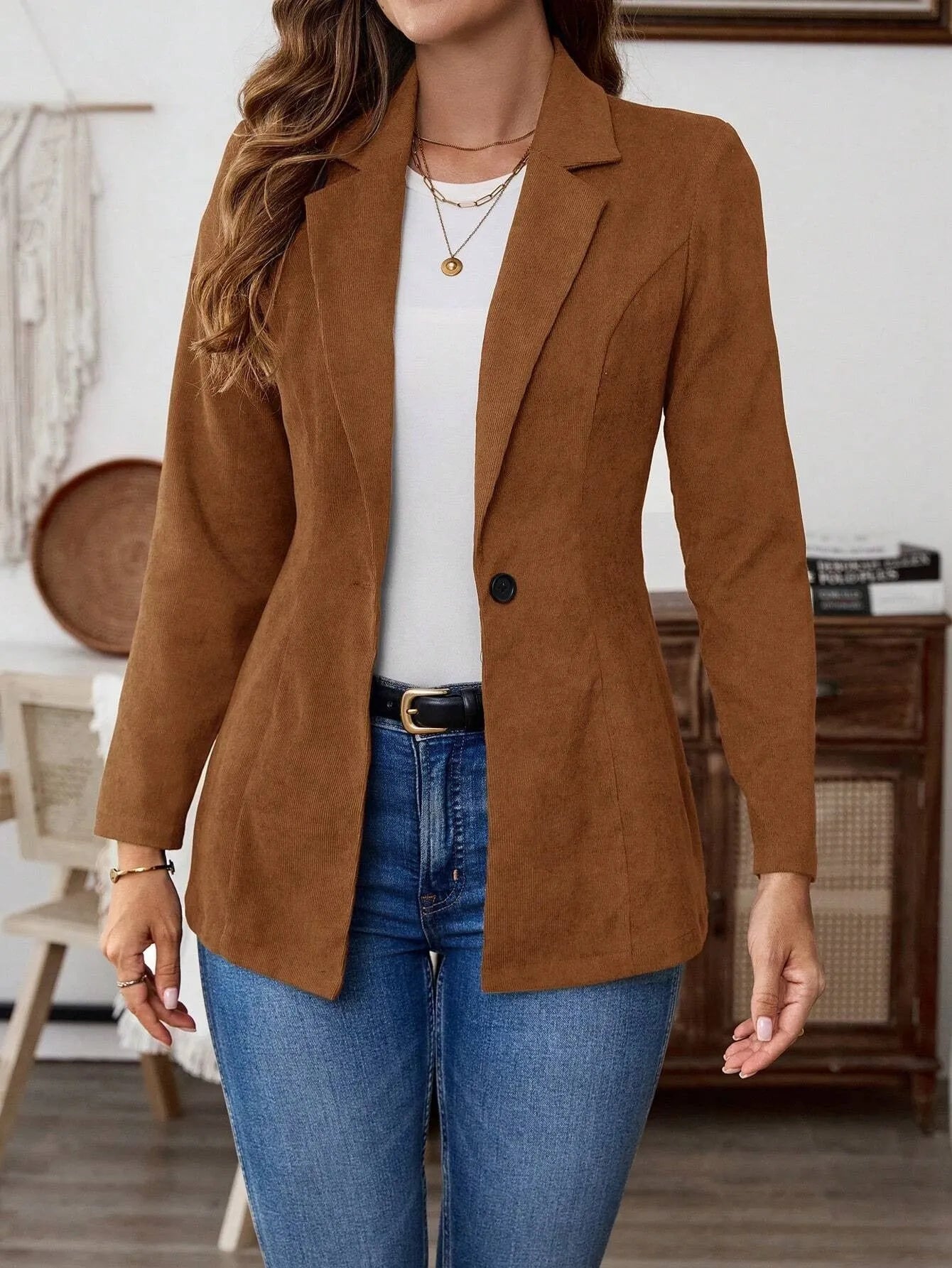Brown men's single-breasted lapel blazer with long sleeves on a hanger.