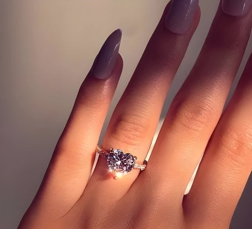 White gold alloy heart-shaped ring with AAA zircon stone on a light background