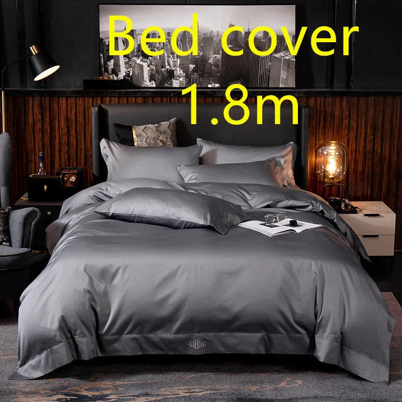 Four-piece cotton satin quilted bedding set with duvet cover, sheet, and pillowcases in a bedroom setting