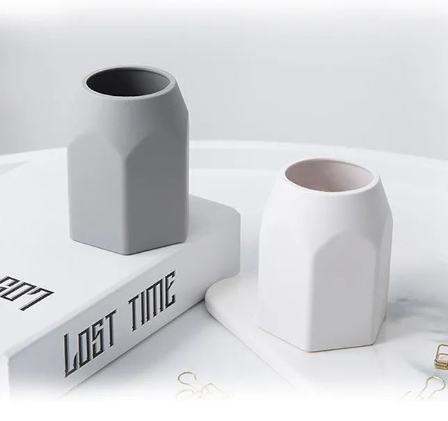 Round silicone pen holder in grey, 80x95mm, on a desk holding pens and pencils