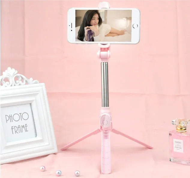 Bluetooth selfie stick tripod with aluminium pole extended, showing phone clip rotation and foldable legs
