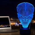 A 3D LED table lamp showing multiple colour lights, sitting on a square base with a USB cable and remote control.