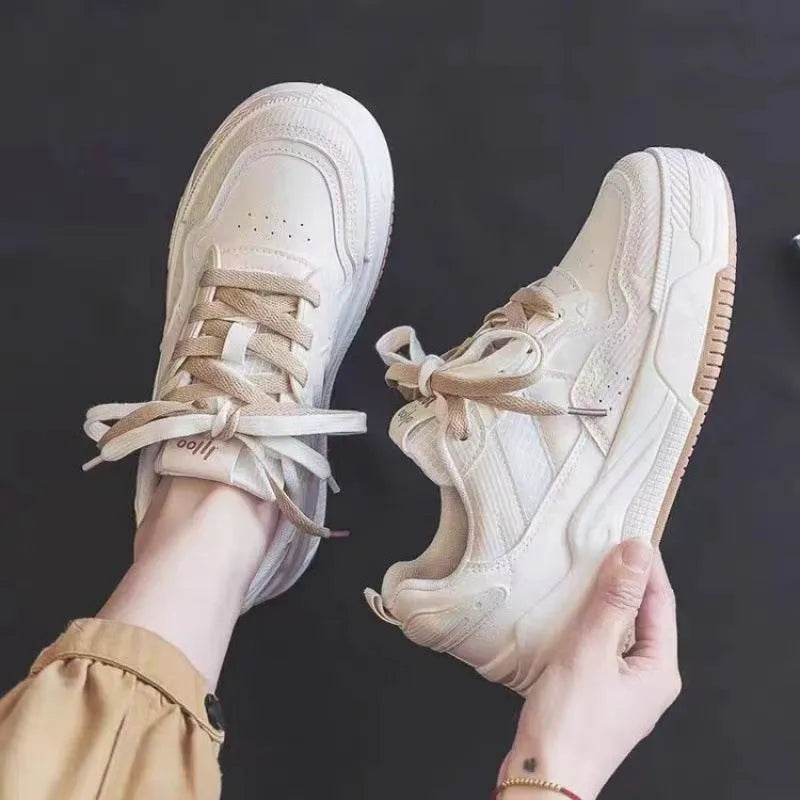 Women's pink and beige low-top sneakers with a rubber sole for height increase.