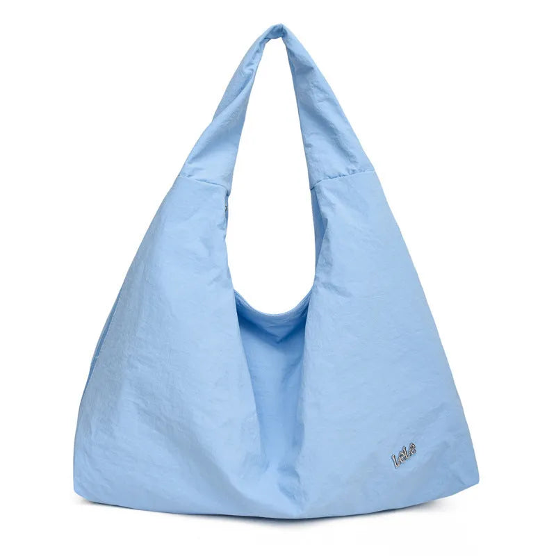 Soft heart-shaped nylon underarm bag for women in yellow, shown worn crossbody.