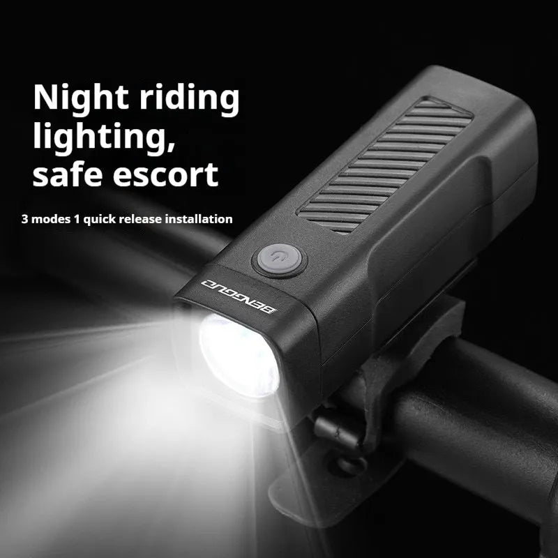 A black USB rechargeable bicycle headlight with a quick-release strap mount on a handlebar.