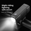 A black USB rechargeable bicycle headlight with a quick-release strap mount on a handlebar.