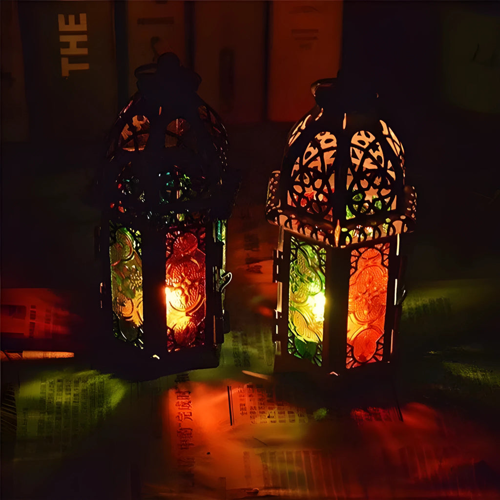 Handmade wrought iron hanging candle holder in black, 16cm tall and 7cm diameter, with a lit candle