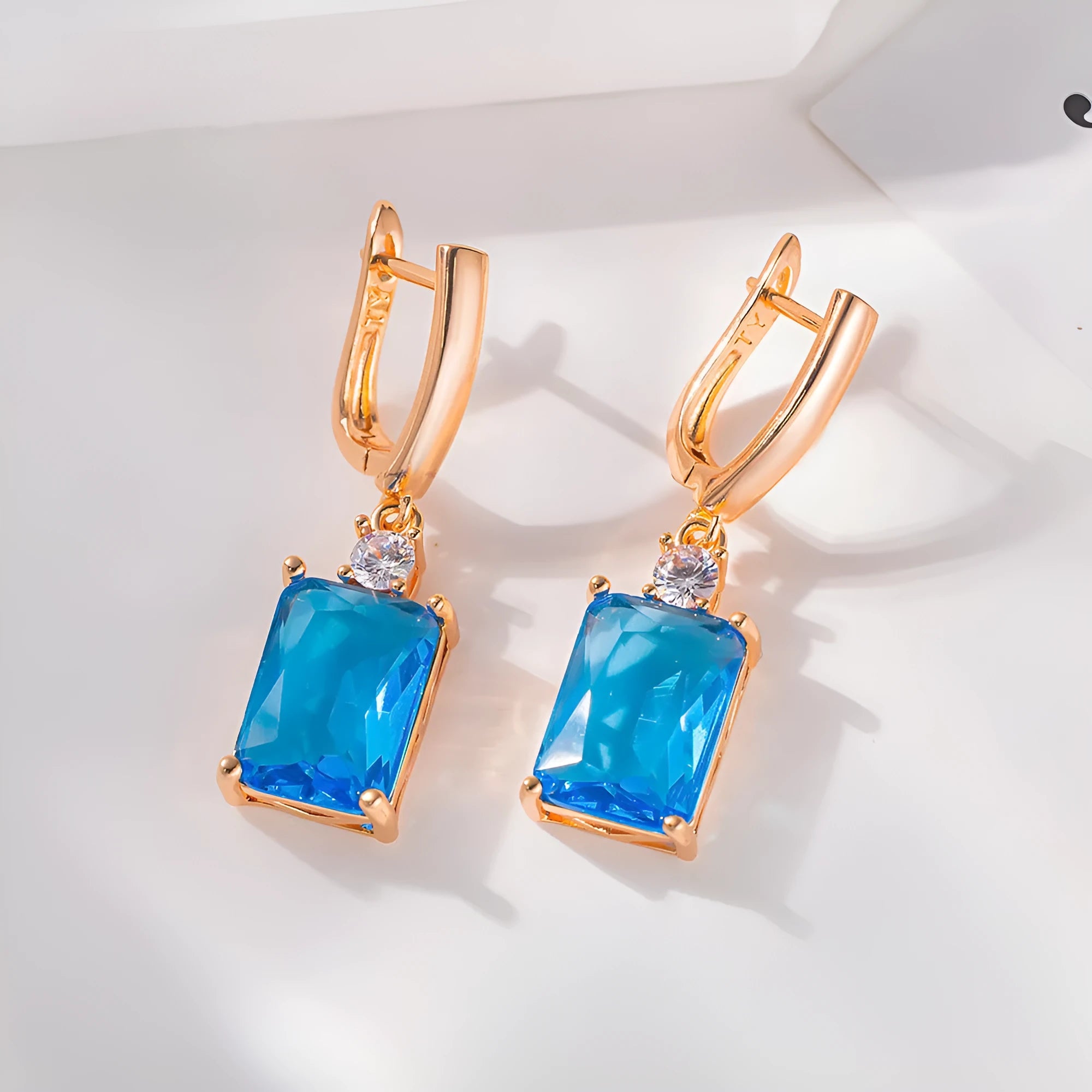 A pair of square geometric earrings with a gold electroplated finish on a copper base.