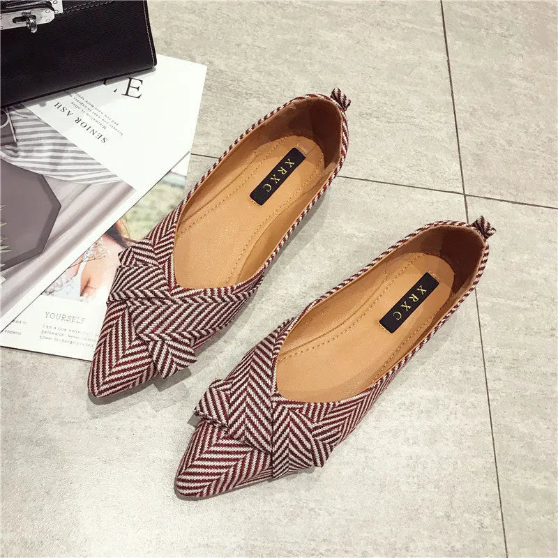 Women's red pointed toe flat shoes with a shallow V-neck opening and low flat heel.