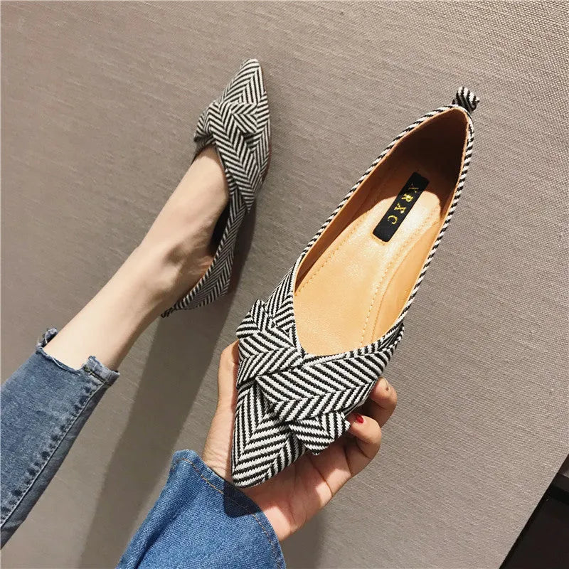 Women's red pointed toe flat shoes with a shallow V-neck opening and low flat heel.