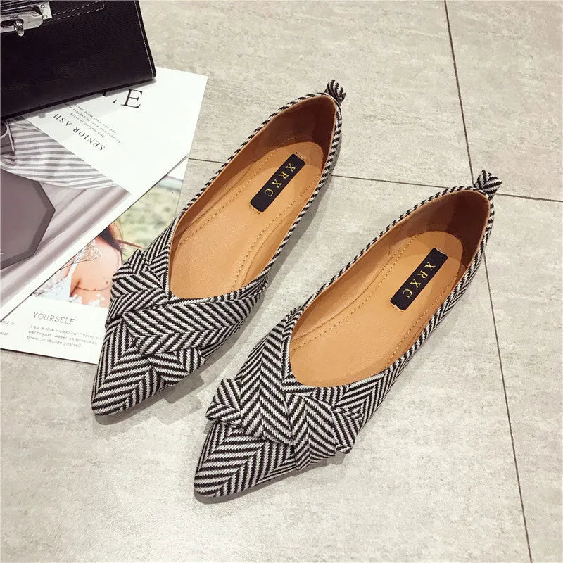 Women's red pointed toe flat shoes with a shallow V-neck opening and low flat heel.