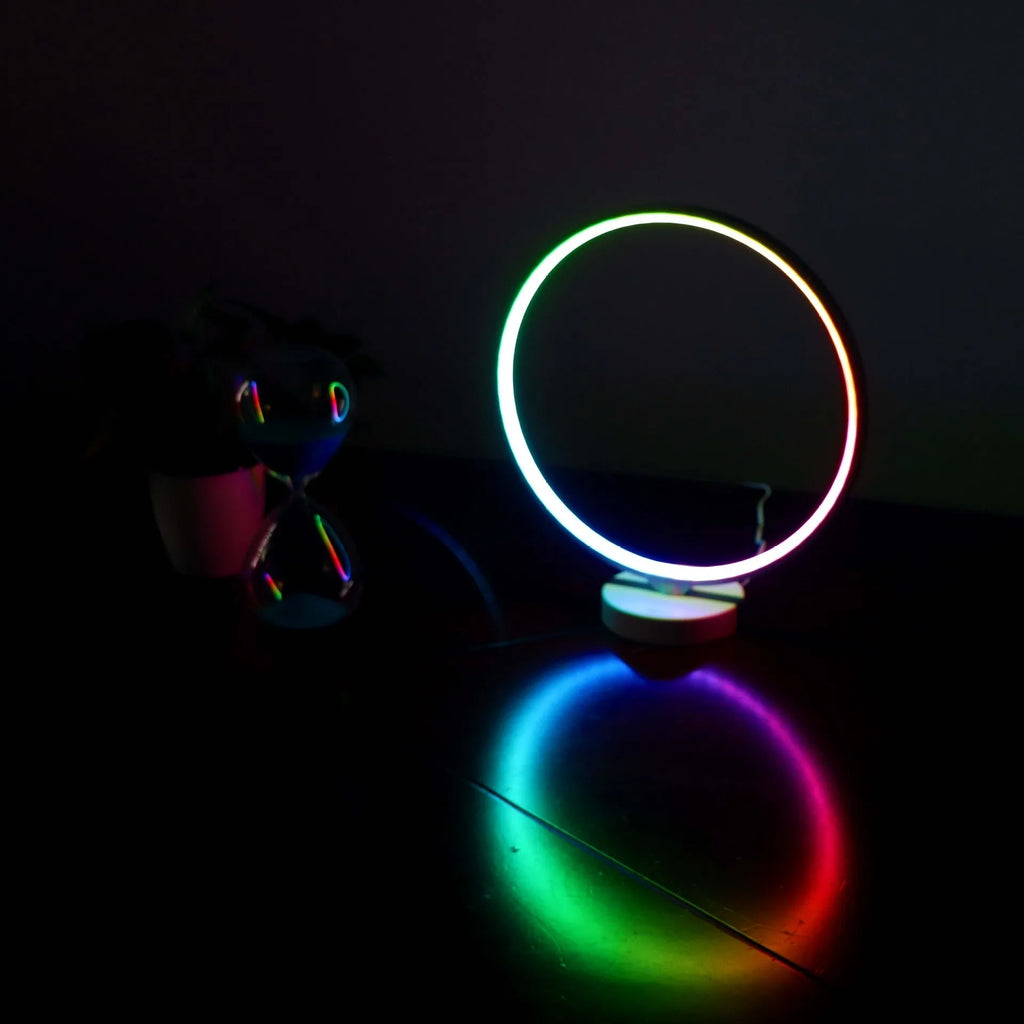 White Full Moon shaped mood lamp with remote control on a wooden desk.