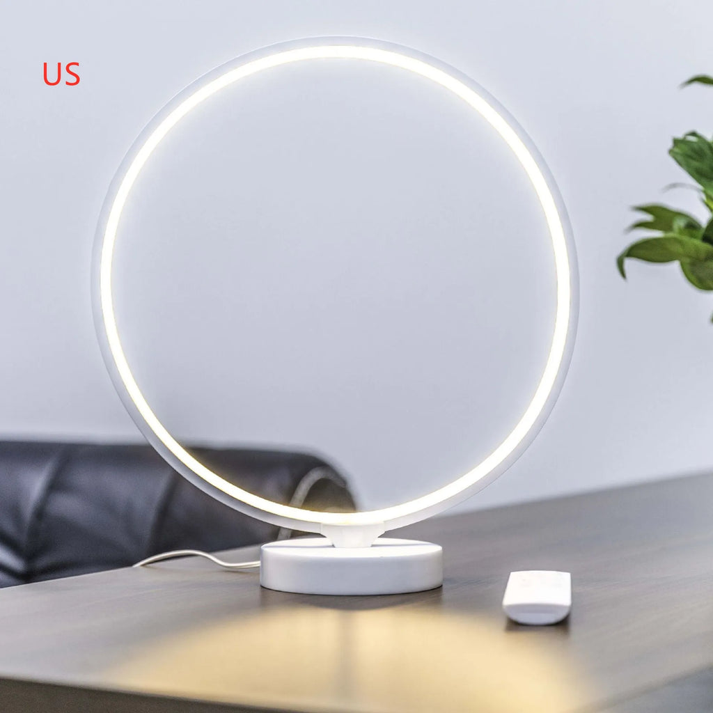White Full Moon shaped mood lamp with remote control on a wooden desk.