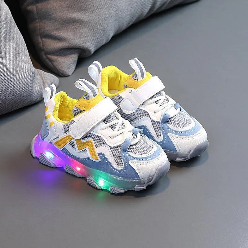Children's black mesh sneakers with a Velcro strap, shown on a child's foot.