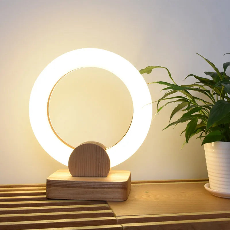 Wooden art circular Nordic style chandelier with a round acrylic shade, shown in a living room setting.