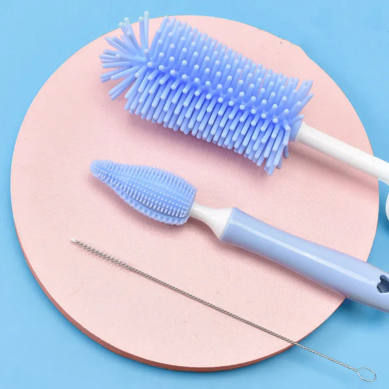 Baby bottle brush set with silicone bristles and a small straw cleaning brush in pink, blue, and yellow colours.