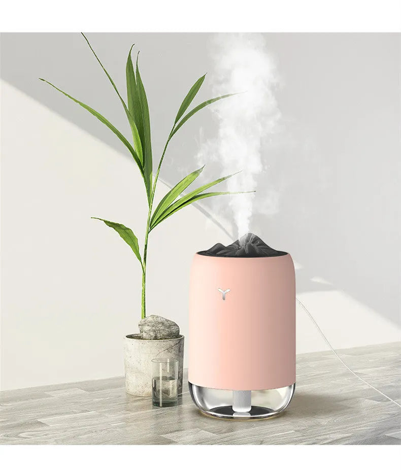 White columnar Magic Flame ultrasonic humidifier with USB cable on a wooden desk