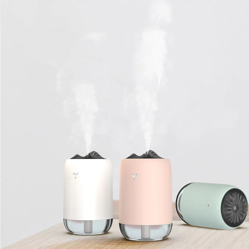 White columnar Magic Flame ultrasonic humidifier with USB cable on a wooden desk