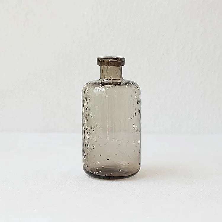 Grey geometric bubble-shaped stained glass vase on a wooden surface.