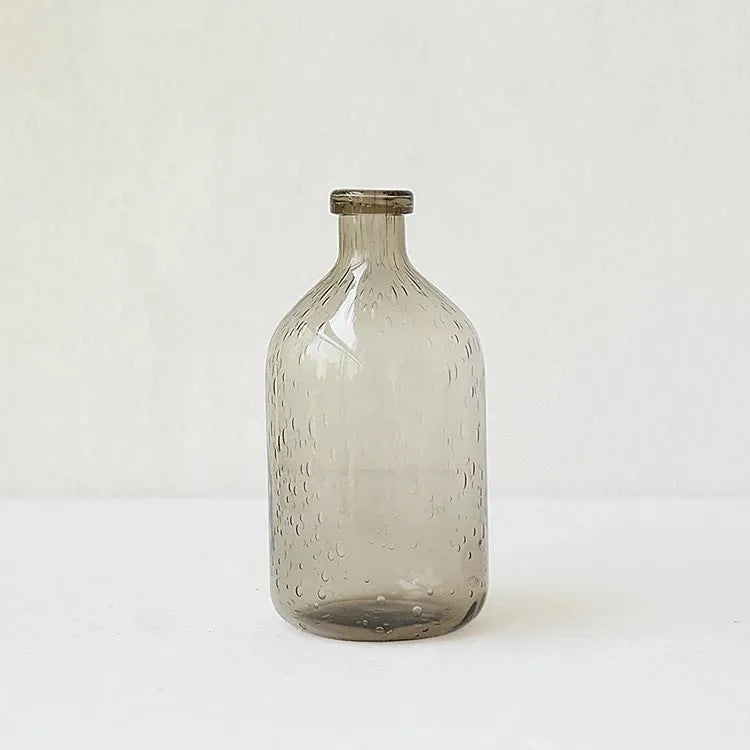 Grey geometric bubble-shaped stained glass vase on a wooden surface.