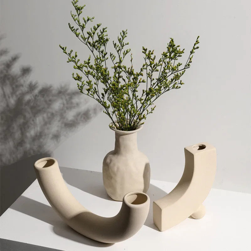 Modern minimalist painted ceramic vase with geometric shape, handmade pottery ornament on shelf