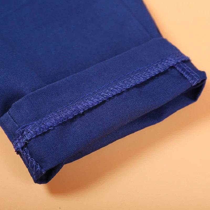 Blue boys' suit set with turtleneck, waistcoat, tie, and trousers on a hanger.