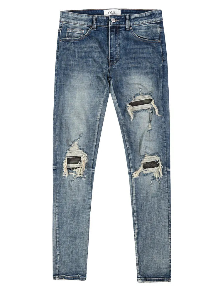 Mens ripped washed blue cotton denim jeans with middle-waisted zip fly, side view on model