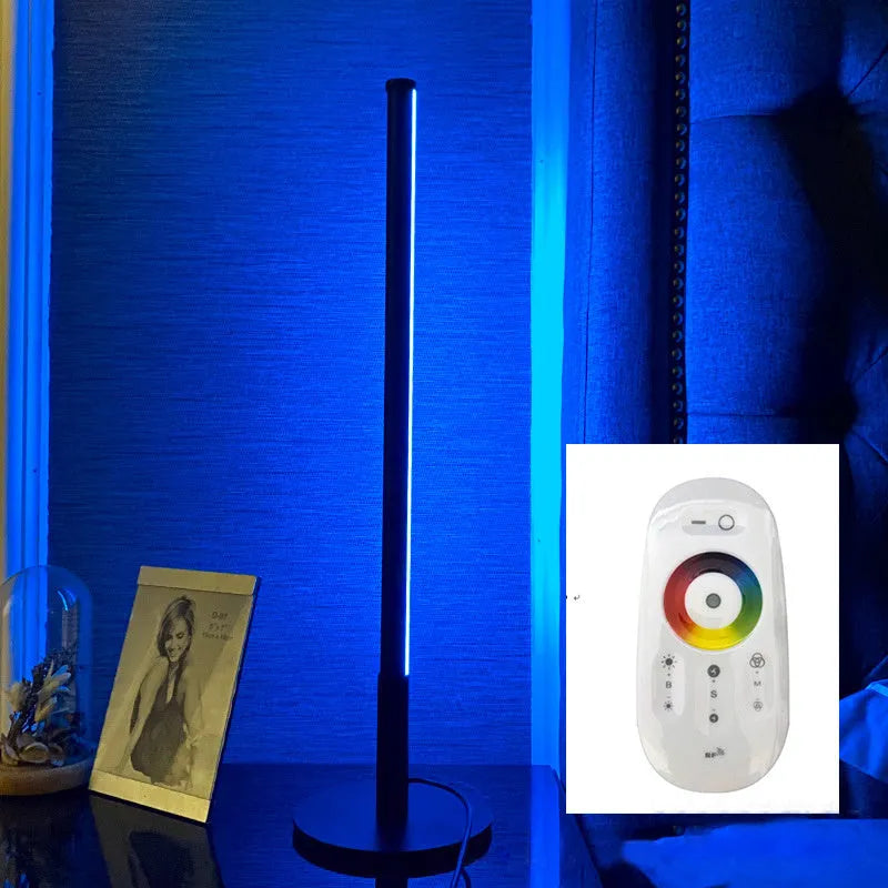 Nordic minimalist black or gold LED table lamp with RGB colour touch remote control on a bedside table.