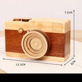 Cute camera-shaped wooden music box with rotating mechanism on pine wood base.
