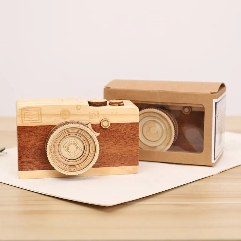Cute camera-shaped wooden music box with rotating mechanism on pine wood base.