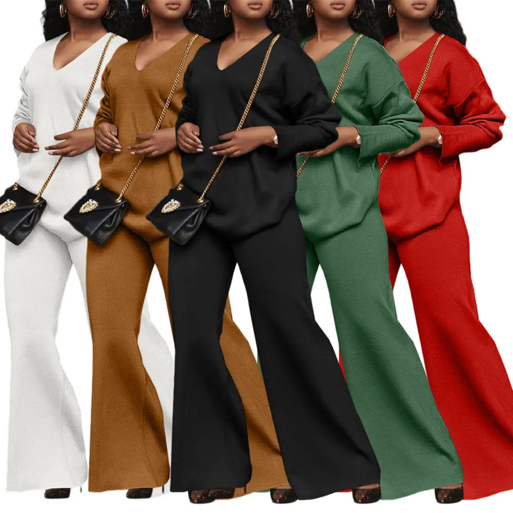 Brown women's suede two-piece suit with split sleeves and matching trousers on a hanger.