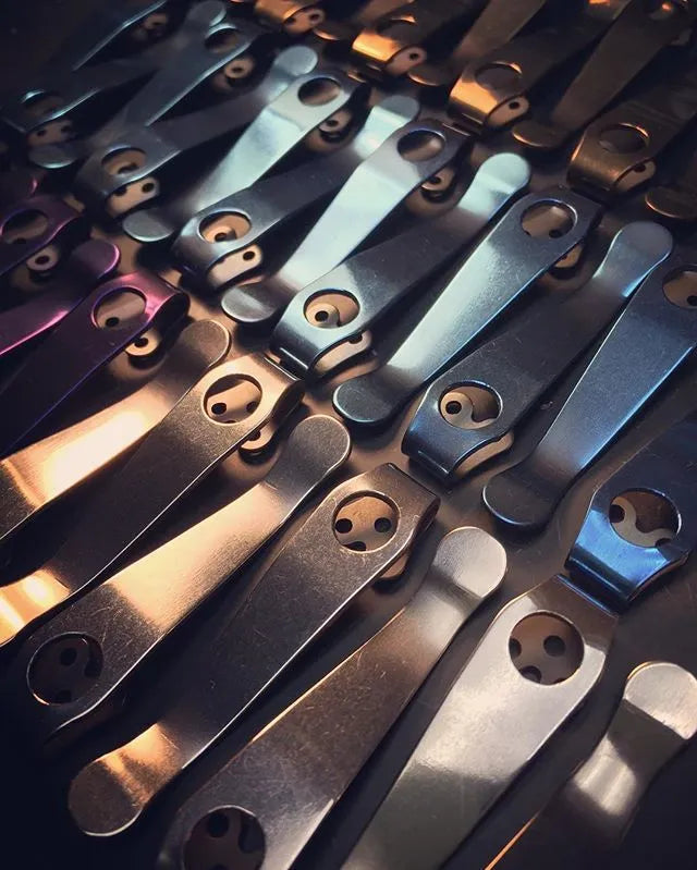 Titanium alloy knife holder with black stone wash finish and back clip for belt or waistband carry.